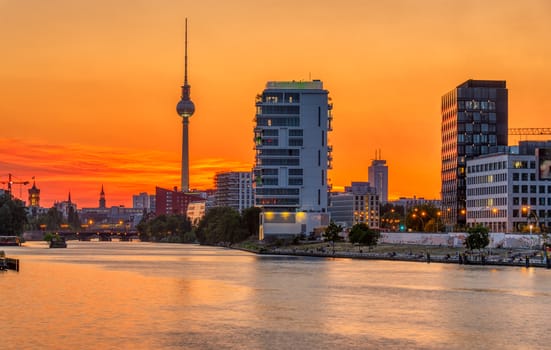 Dramatic sunset at the river Spree in Berlin with the famous Television Tower in the back