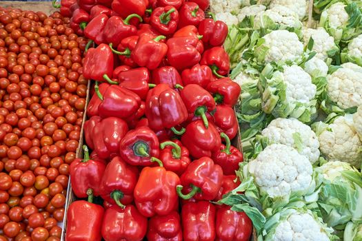 Cauliflower, red peppers and tomatoes for sale at a market