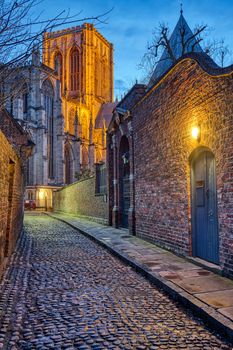 Small cobbled street in York at night with the famous Minster in the back