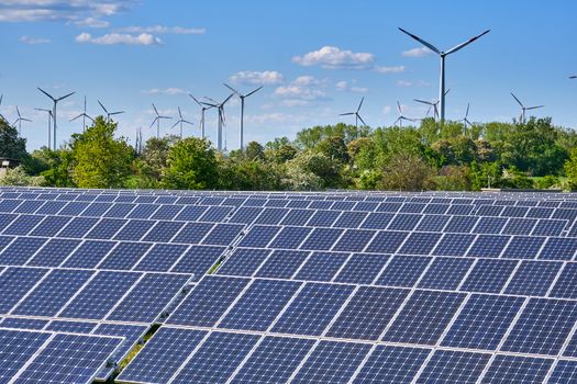 Solar panels with wind turbines in the back seen in Germany