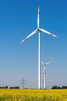 Wind turbines, power lines and flowering rapeseed seen in Germany