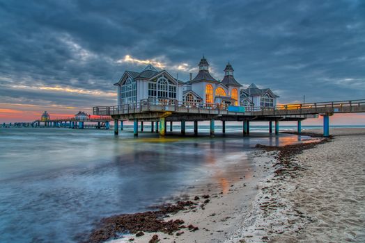 The sea pier of Sellin on Ruegen island in Germany with dark clouds before sunrise