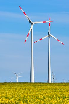 Wind turbines in a thriving rapeseed field seen in Germany