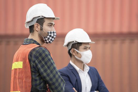 Business man and  Factory workers wearing in a medical mask and safety cloth at outdoor factory cargo warehouse.