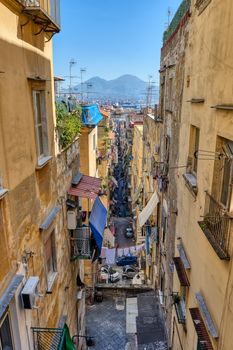 Narrow alleyway in the old town of Naples with Mount Vesuvius in the back