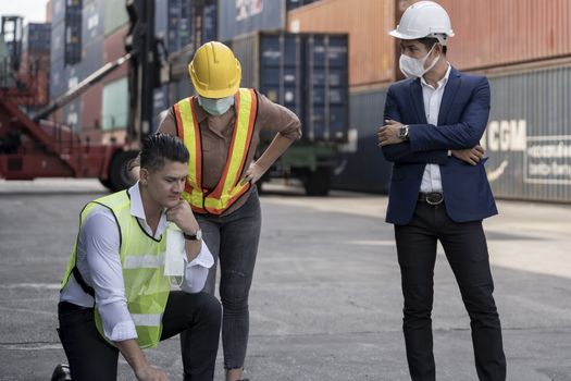 group people worker is wearing protection mask face and safety helmet and wearing suit safety dress With background of container cargo warehouse. Concept of industry worker operating.