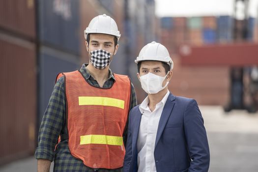 Business man and  Factory workers wearing in a medical mask and safety cloth at outdoor factory cargo warehouse.