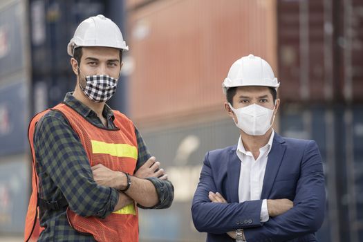 Business man and  Factory workers wearing in a medical mask and safety cloth at outdoor factory cargo warehouse.