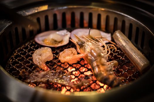 Barbecue grilled seafood cooking on hot flaming grill.