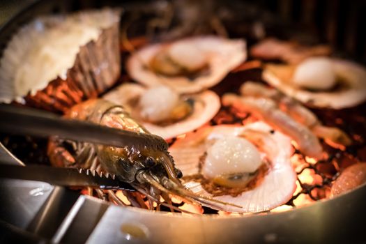 Barbecue grilled prawn seafood cooking on hot flaming grill.