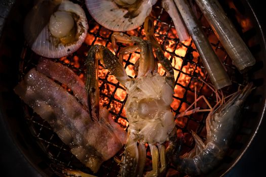 Barbecue grilled crab seafood cooking on hot flaming grill.