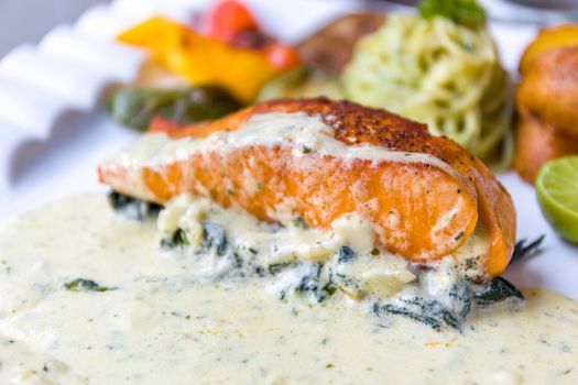 Grille salmon with white sauce and spinach.