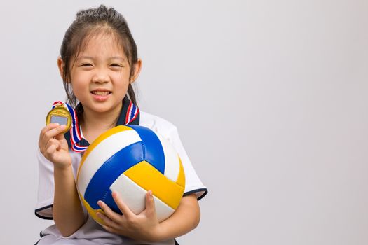 Kid holding ball and gold medal, studio shot, isolated on white.