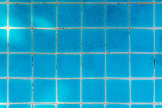Blue tile of swimming pool in square pattern.