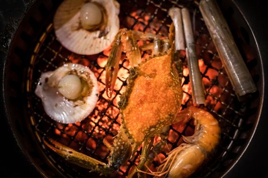 Barbecue grilled crab seafood cooking on hot flaming grill.