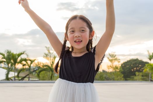 Child raising hands for success with happiness and joy.
