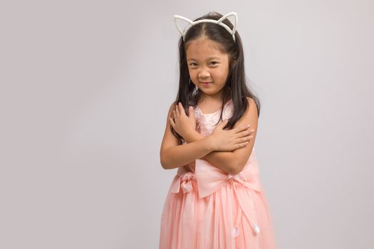 Child with cat ear headband, isolated on white background.