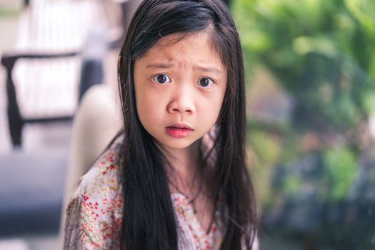 Angry facial expression showed by Asian child.
