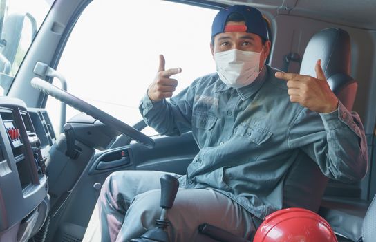 Close-up photos of Asian truck drivers wearing masks to protect against dust and the spread of the flu. Covid 19. Inside the car front