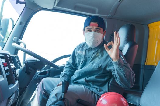 Close-up photos of Asian truck drivers wearing masks to protect against dust and the spread of the flu. Covid 19. Inside the car front