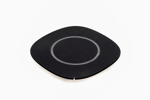 Isolated wireless charger for smartphone on white background.