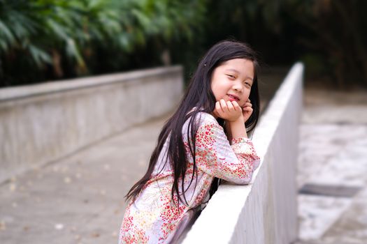 Asian child smiling with happiness in outdoor park.