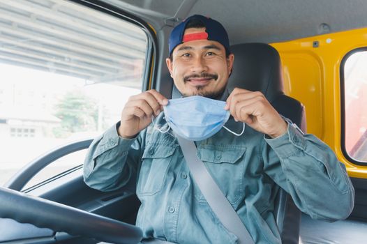 Close-up photos of Asian truck drivers wearing masks to protect against dust and the spread of the flu. Covid 19. Inside the car front