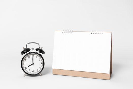 Blank paper spiral calendar for mockup template advertising and branding with clock on gray background.