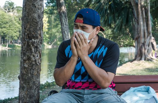 A young Asian man wearing a mask to prevent the spread of the virus. Men are unemployed due to a virus outbreak.