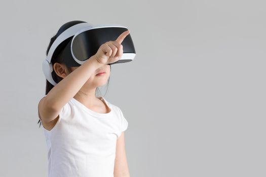 Studio shot of child with virtual reality, VR, headset, isolated on white background. Kid wearing VR goggles to explore digital virtual world.