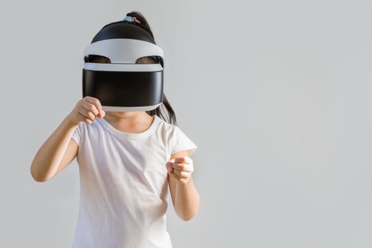 Studio shot of child with virtual reality, VR, headset, isolated on white background. Kid wearing VR goggles to explore digital virtual world.