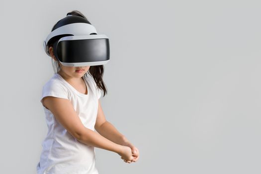 Studio shot of kid with virtual reality, VR, headset, isolated on white background. Child wearing VR goggles to explore digital virtual world.