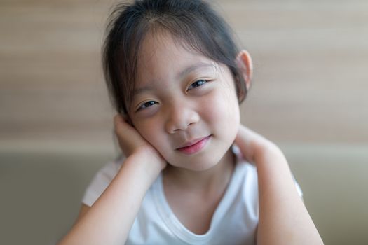 Headshot of smiling Asian child, girl, illustrating happiness concept.
