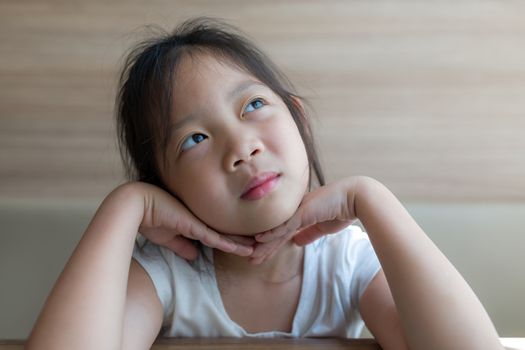 Asian child, girl, thinking and looking up to sky illustrating imagination concept.
