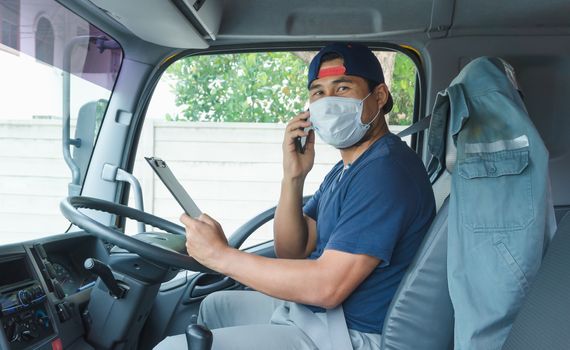 Close-up photos of Asian truck drivers wearing masks to protect against dust and the spread of the flu. Covid 19. Inside the car front