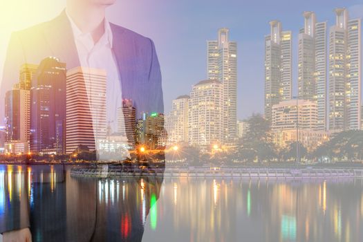 Business leadership concept shown by businessman in suit with urban city background in double exposure.