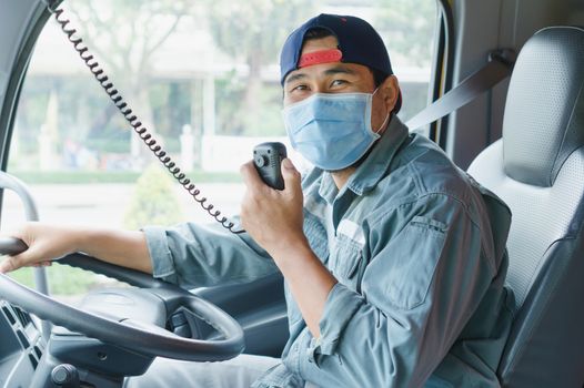 Close-up photos of Asian truck drivers wearing masks to protect against dust and the spread of the flu. Covid 19. Inside the car front