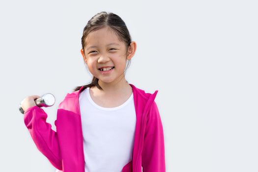 Studio shot of Asian child wearing sweater holding dumbbell, isolated on white background.