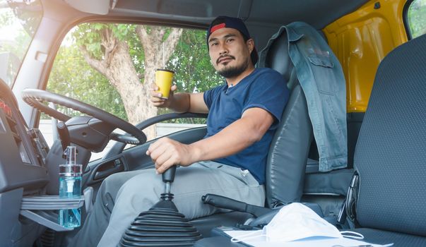 An elderly Asian man is driving a truck to deliver goods to customers. He is the owner of the transportation business.