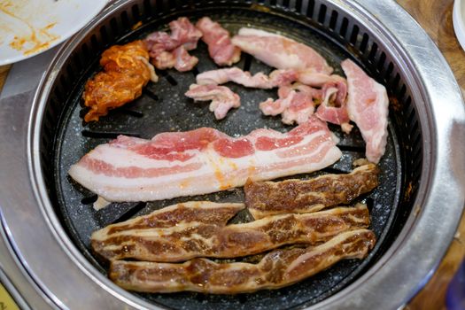 Korean BBQ grilled pork and beef cooking.