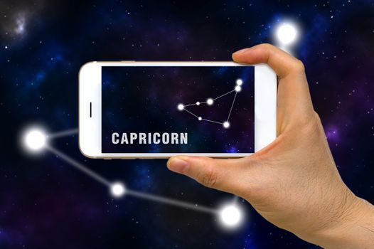 Concept of augmented reality, AR, of Capricorn zodiac constellation app on smartphone.