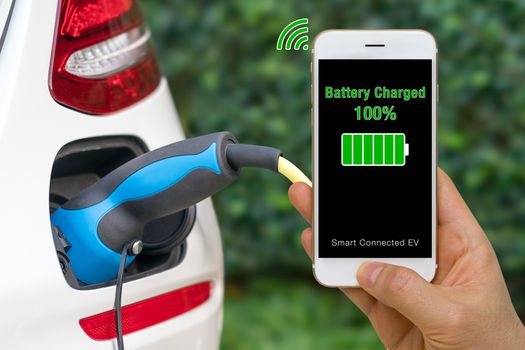 Smartphone show status of battery charged in smartphone app of connected car.