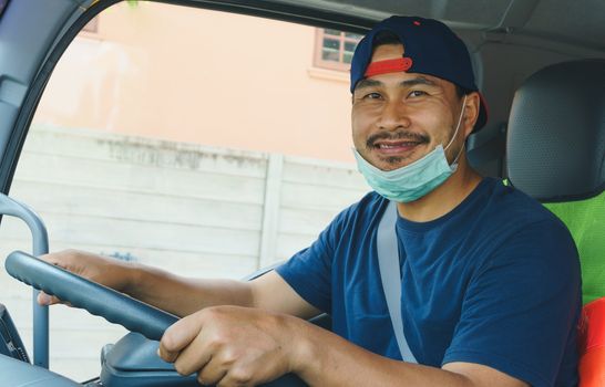 Close-up photos of Asian truck drivers wearing masks to protect against dust and the spread of the flu. Covid 19. Inside the car front