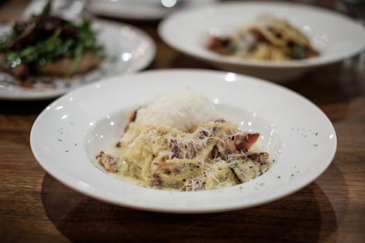 Spaghetti carbonara with bacon and cheese in plate.