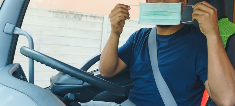 Close-up photos of Asian truck drivers wearing masks to protect against dust and the spread of the flu. Covid 19. Inside the car front