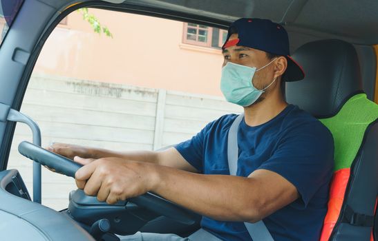 Close-up photos of Asian truck drivers wearing masks to protect against dust and the spread of the flu. Covid 19. Inside the car front