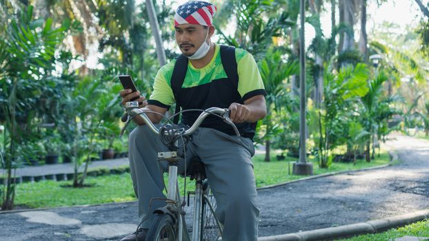 Asian male workers wear masks to prevent and stop infection Virus. Biking in a public garden makes the body immune to disease.