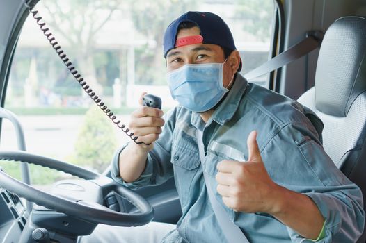 Close-up photos of Asian truck drivers wearing masks to protect against dust and the spread of the flu. Covid 19. Inside the car front