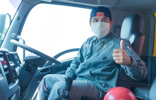 Close-up photos of Asian truck drivers wearing masks to protect against dust and the spread of the flu. Covid 19. Inside the car front