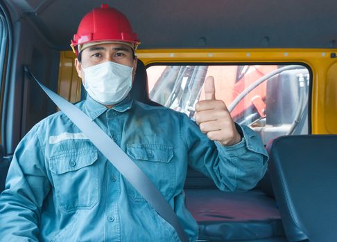 Close-up photos of Asian truck drivers wearing masks to protect against dust and the spread of the flu. Covid 19. Inside the car front